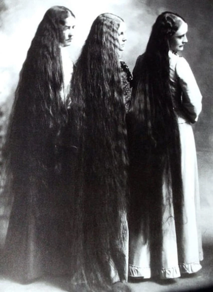 Antique black-and-white portrait of three long-haired women