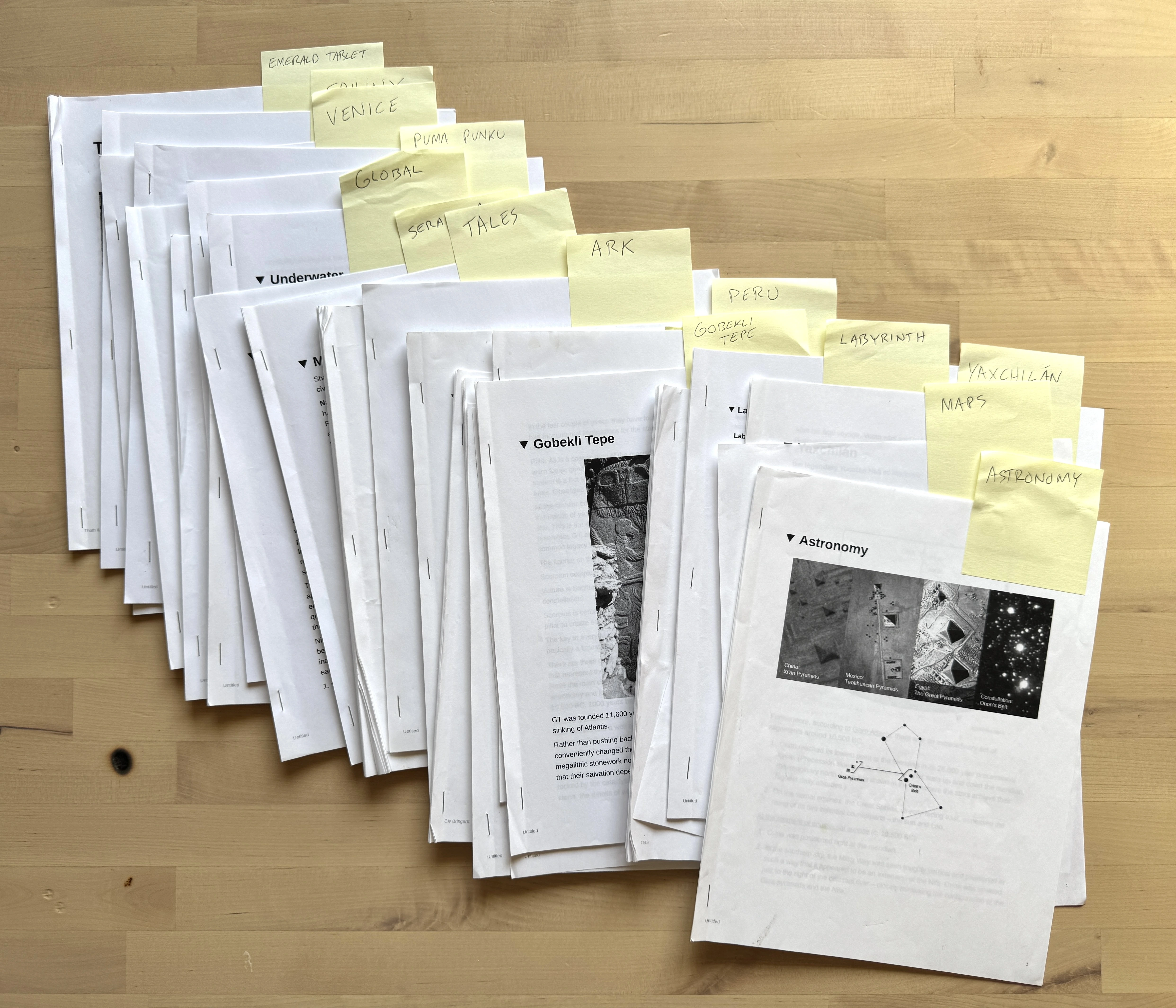 Stacks of physical research packets organized by subject with labeled tabs